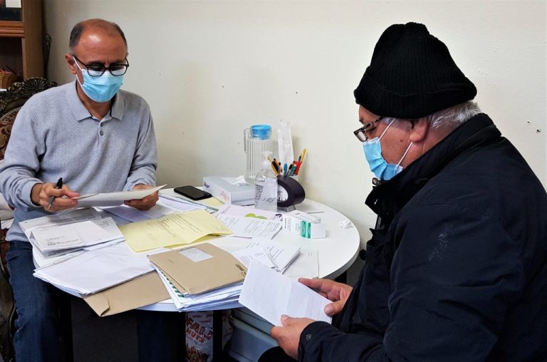 An advice worker and client going through paperwork during the coronavirus pandemic